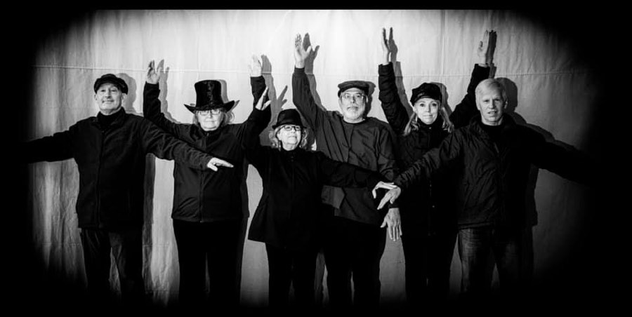 All Together Now in black and white, arms raised in a Beatles Help! pose